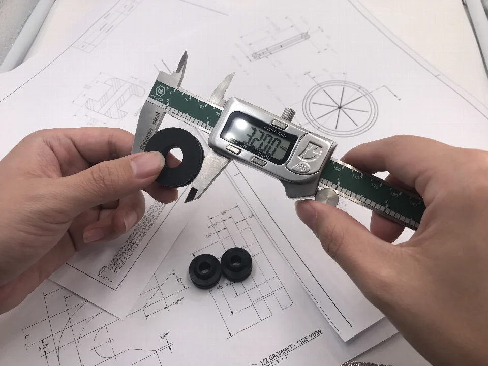Measuring a rubber grommet sample with a digital caliper